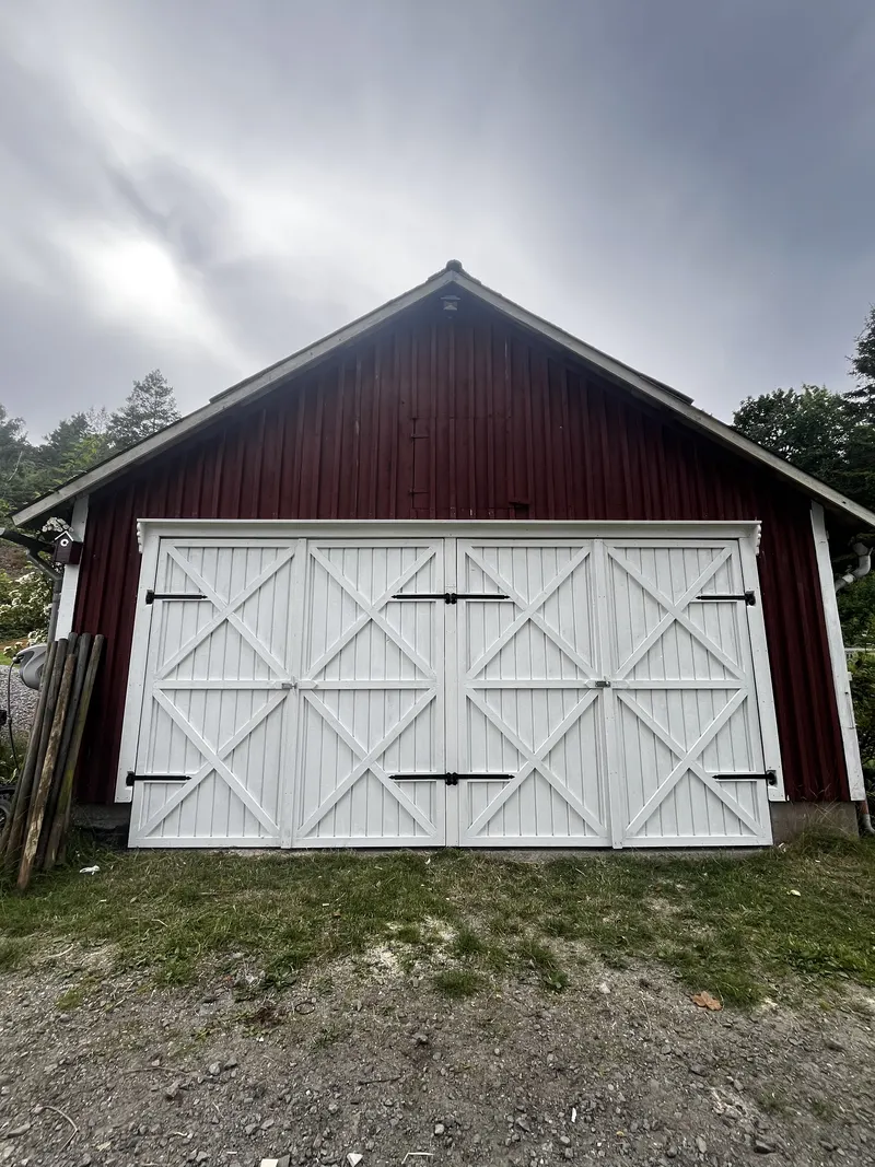 Röd lada med nya vita portar