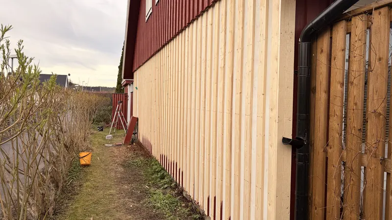 Ny omålad fasadpanel monterad längs sidan av en byggnad