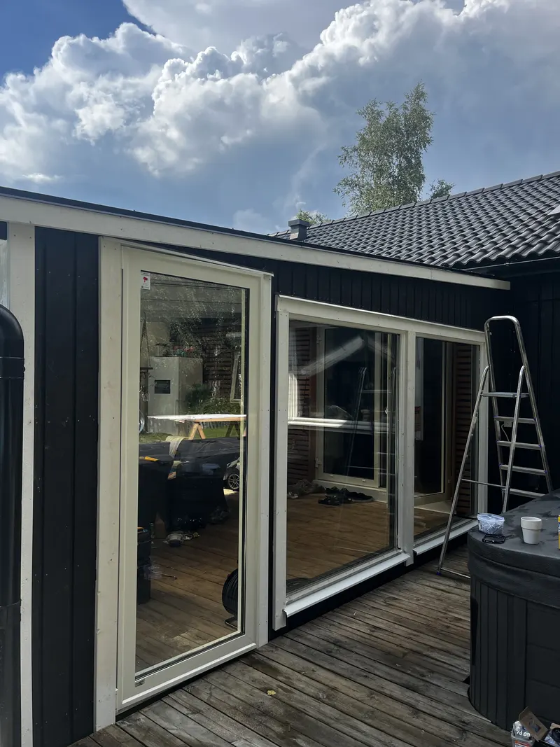 Svart hus med nya glaspartier ut mot altanen