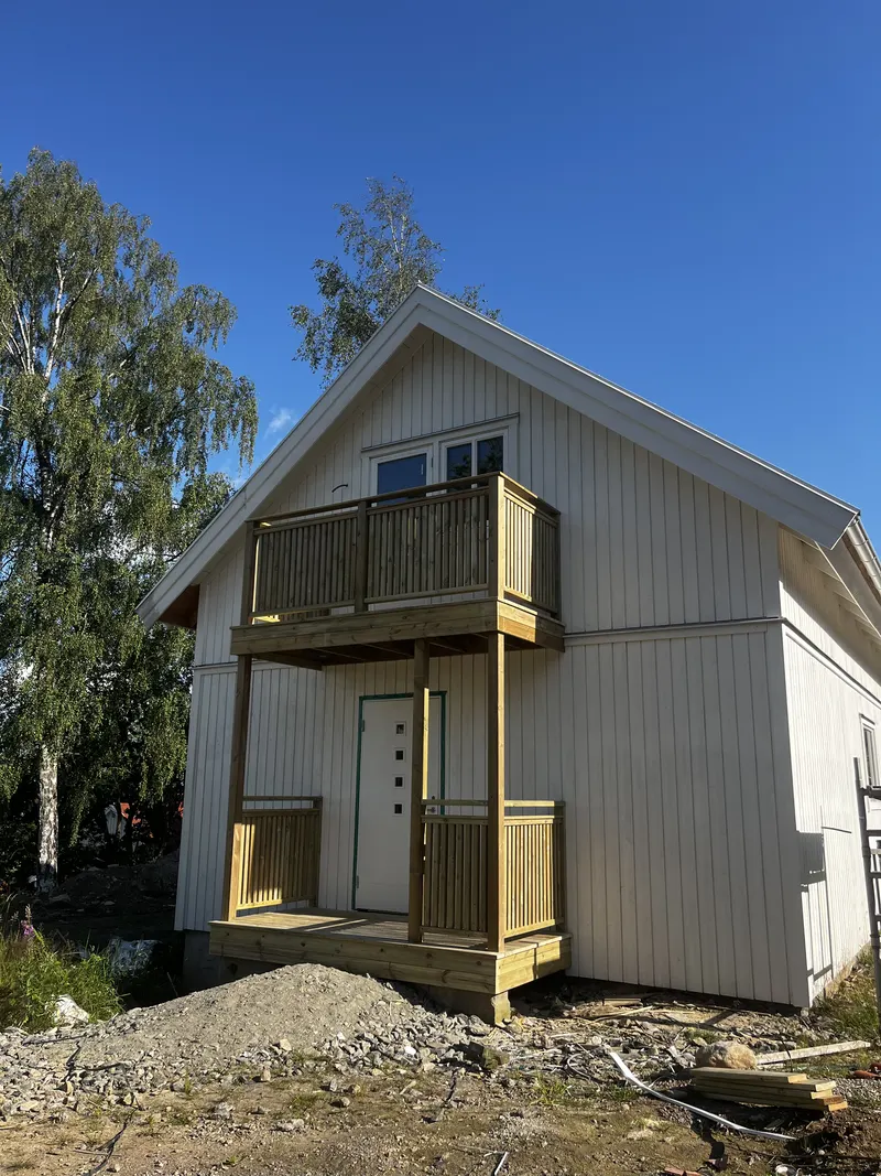 Hus med nybyggd balkong över entrén